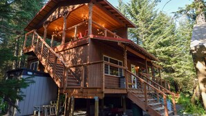 A wooden cabin with a balcony and stairs, surrounded by trees. - Beachfront property located on Resurrection Bay! (Lowell Point)