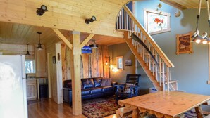 A wooden interior with a dining table, a sofa, and a staircase. - Beachfront property located on Resurrection Bay! (Lowell Point)