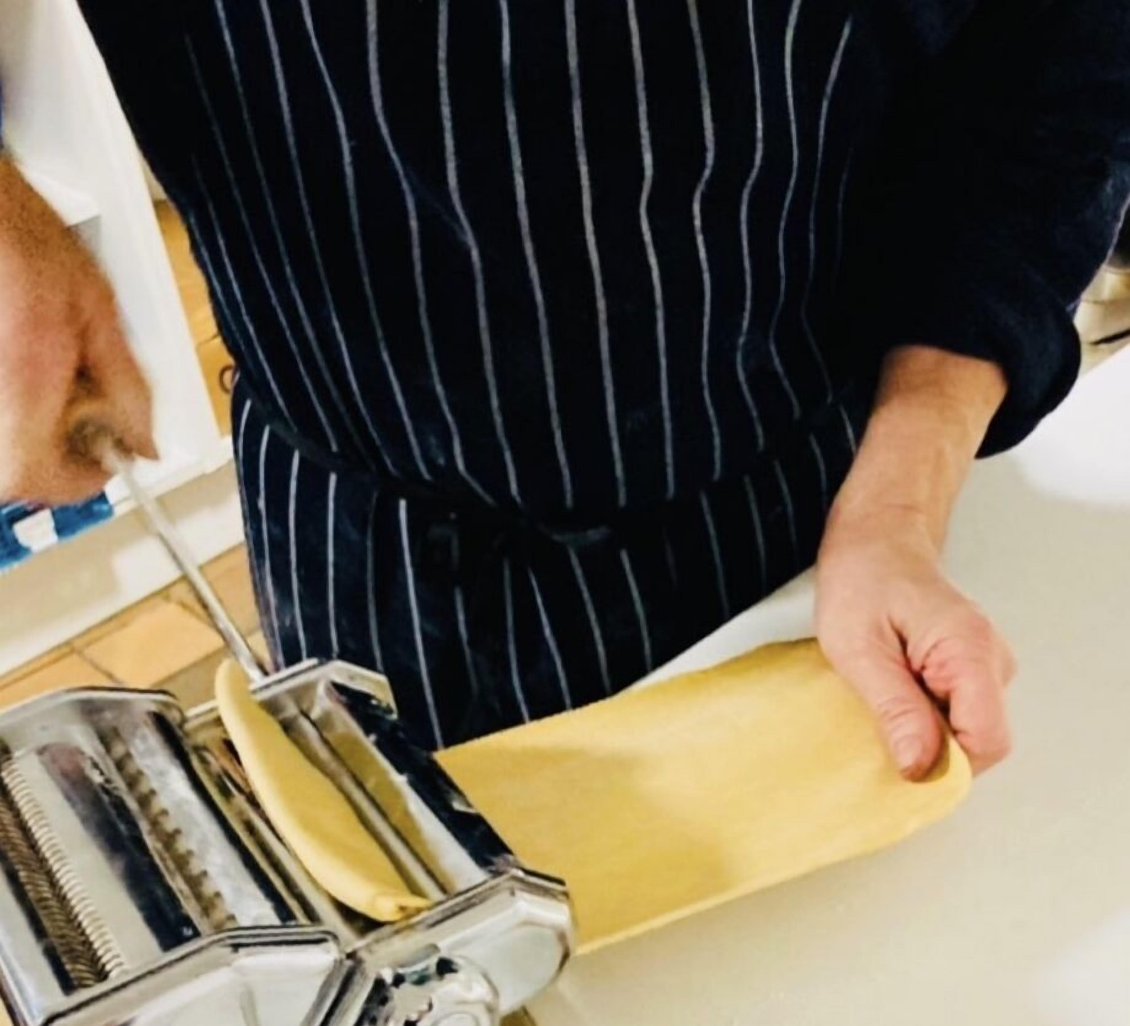 Iemand bedient een pastamachine.
