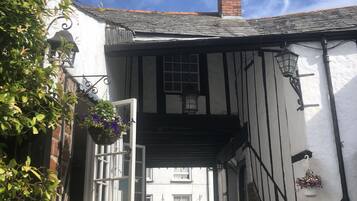 A traditional half-timbered building with a white facade and exposed timber framing.