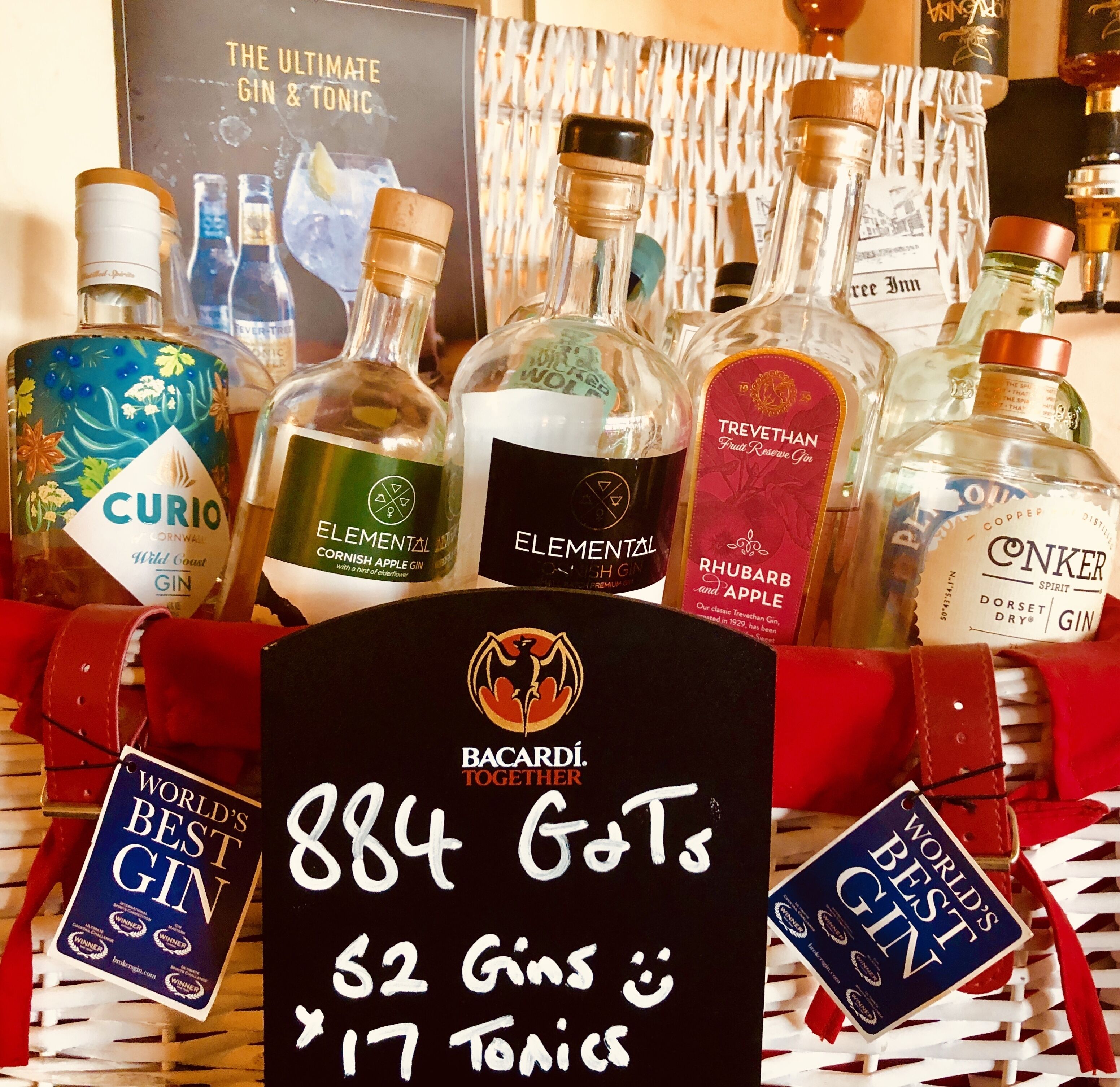 A selection of gin bottles and a sign indicating a gift basket with 884 bottles of gin and 17 bottles of tonic.