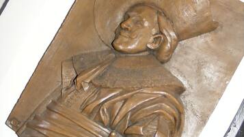 A sculpture of a person in traditional attire, possibly a historical or cultural artifact.