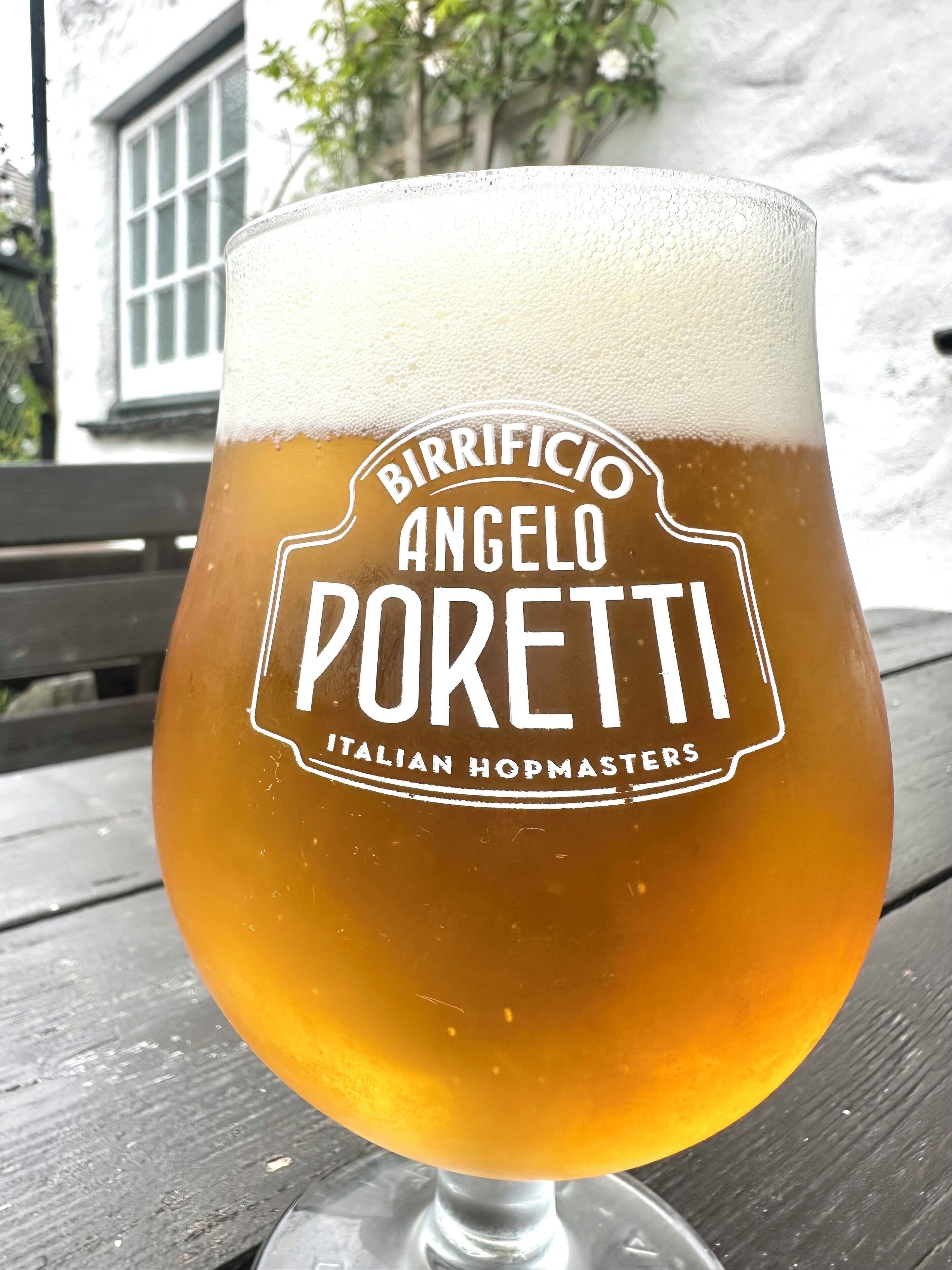 A glass of beer with the label "Birrificio Angelo Poretti Italian Hopmasters."