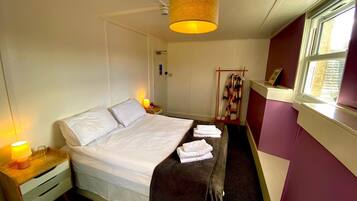 Une chambre d’hôtel avec un lit, une lampe de chevet et une fenêtre donnant sur un paysage agréable.