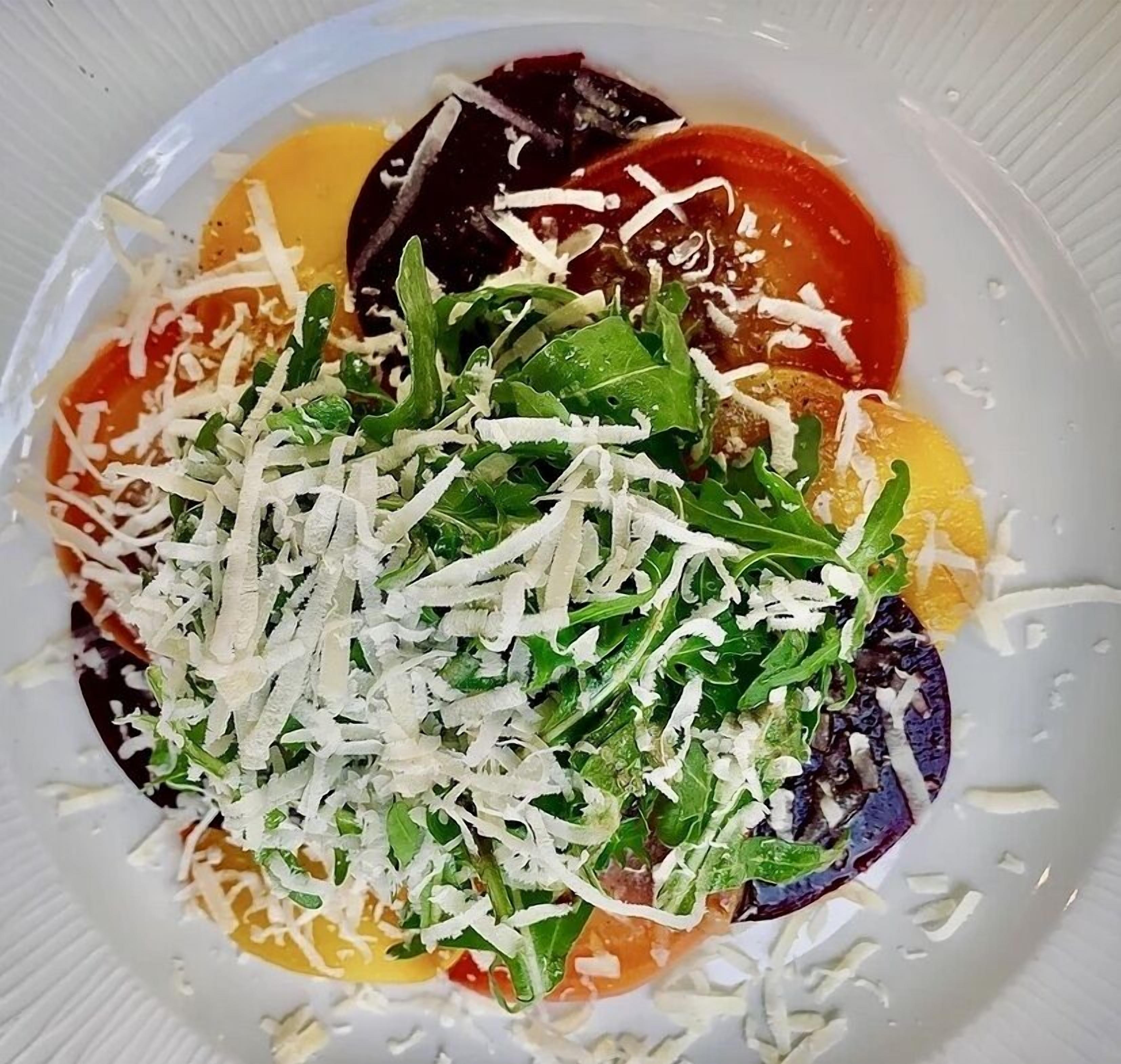 Un plato de comida con varias verduras y queso.