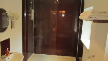 A modern bathroom with a glass-enclosed shower, a sink, and a toilet.