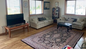 A living room with two sofas, a coffee table, a TV, and a bookshelf.