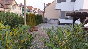 A residential area with a paved courtyard, a wooden pergola, and a row of houses with different architectural styles. - Apartma Transpet (Kostelec na Hané)