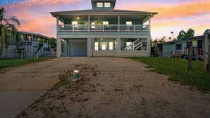 Ein zweistöckiges Gebäude mit einem Balkon im oberen Geschoss, einer Garage und einer Treppe, die zu dieser Etage führt.