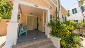 Una casa amb porxo, número 1318, i una petita zona d'estar amb cadires.