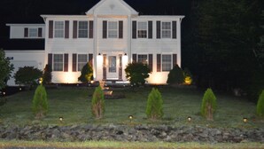 A two-story white house with a symmetrical facade, central entrance, and evenly spaced windows.
