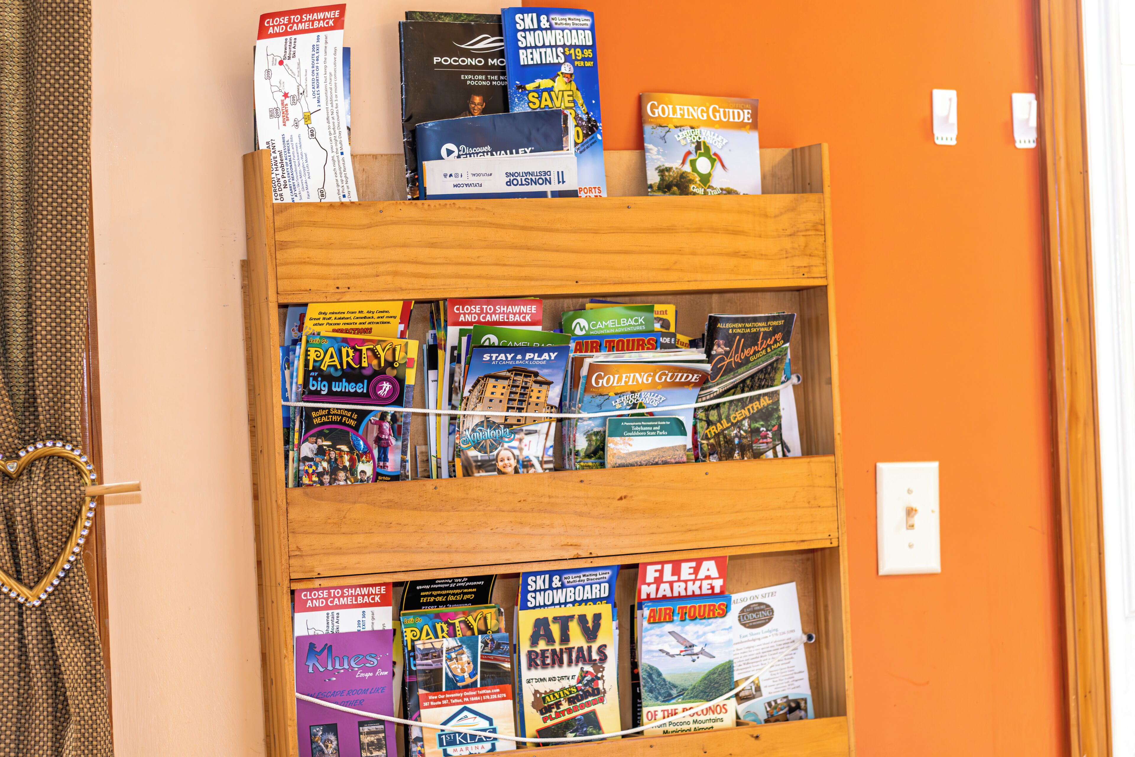 A wooden shelf with travel guides and maps.