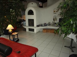 Ein gemütliches Wohnzimmer mit Kamin, einem roten Sofa und einem Couchtisch.