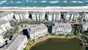 Ein Hotelkomplex an der Küste mit mehreren Gebäuden, einem Innenhof und Blick auf den Strand.