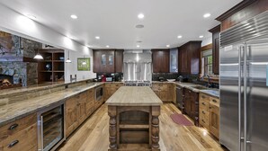 Una cucina moderna con mobili in legno, elettrodomestici in acciaio inossidabile e un'isola centrale.