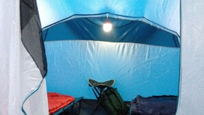 A tent with a sleeping area, a chair, and a pair of shoes. - Burren Bushcraft - Camping & Adventures (Carran)
