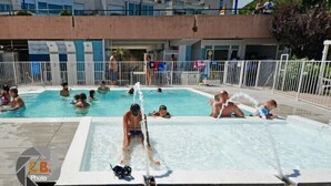 Un área de piscina con varias piscinas y una fuente de agua.