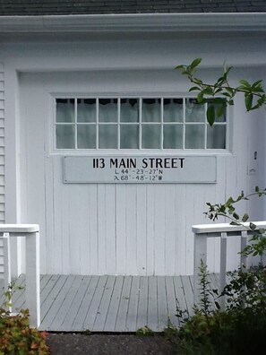 Eine weiße Garagentür mit einem Schild, das '113 Main Street' und Koordinaten zeigt.