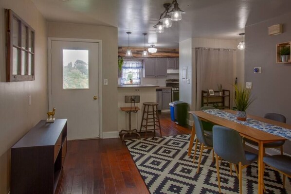 Cocina compacta con comedor, piso de madera y alfombra estampada.
