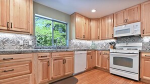 A modern kitchen with wooden cabinets, a built-in microwave, and an oven. - Gorgeous Home on 6 Scenic & Private Acres-Close to many lakes and rivers (Pioneer)