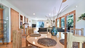 A dining area with a wooden table, woven placemats, and a decorative vase. - Gorgeous Home on 6 Scenic & Private Acres-Close to many lakes and rivers (Pioneer)