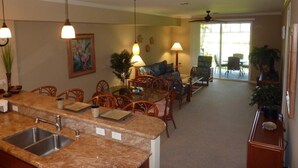 A spacious living area with a kitchen, dining table, and seating.