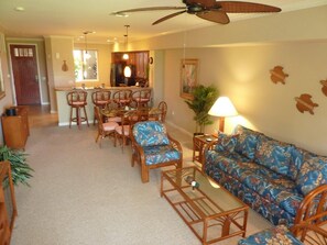 Relax in this open-plan living space with a sofa, dining table, and kitchen counter.