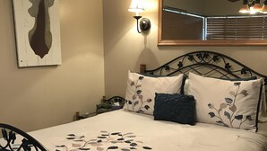 A bedroom with a bed, a nightstand, a lamp, a ceiling fan, and a wall-mounted mirror. - 3BR Townhouse - Your Home Away from Home (mammoth lakes)