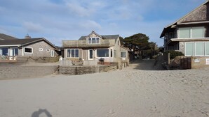 A beachfront property with a wooden house, a sandy beach, and a private beach access sign. - The Haystack House-Cannon Beach Oceanfront Home Steps to Haystack Rock & Midtown (Cannon Beach)