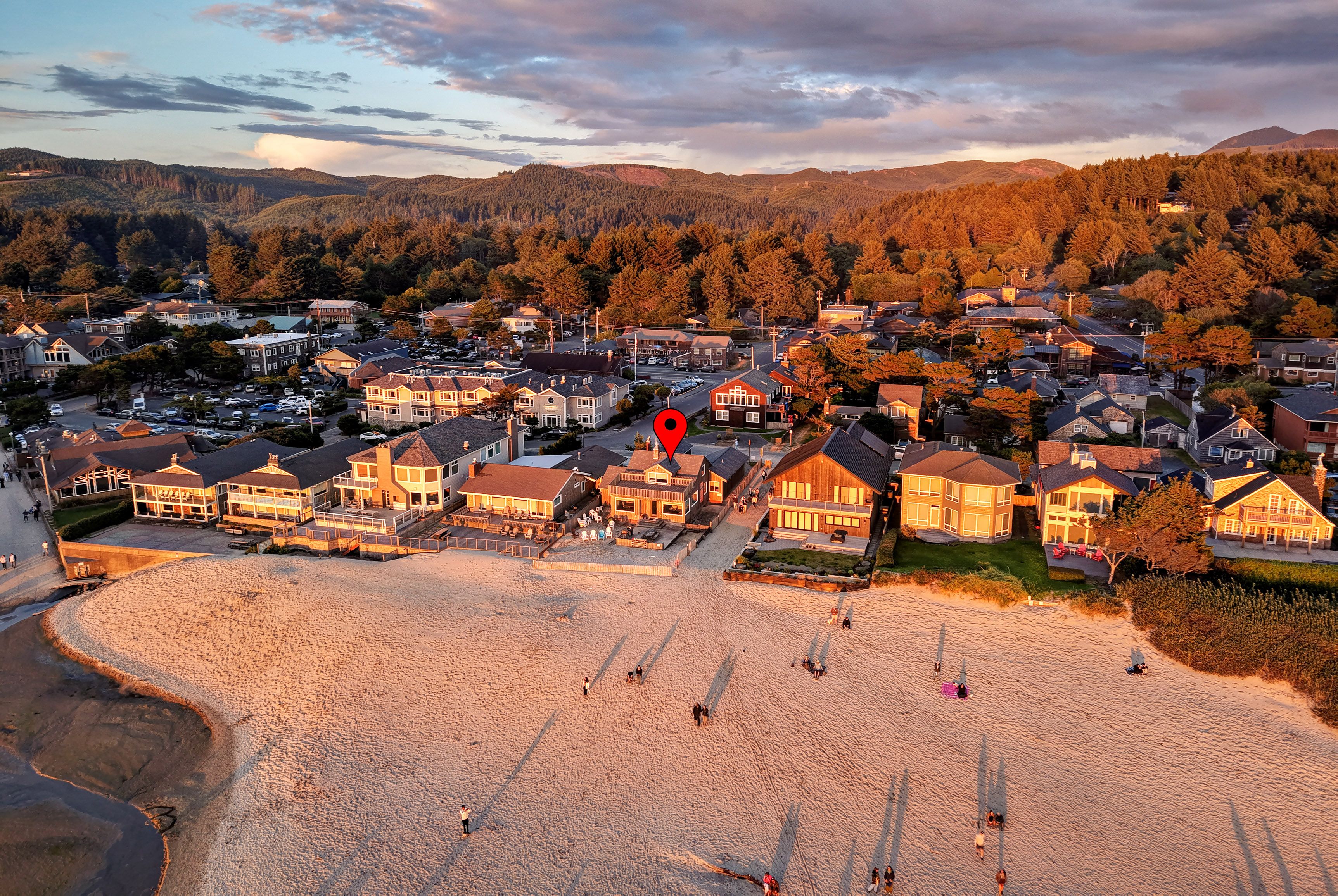A coastal town with beachfront properties, a central square, and a hilly backdrop.