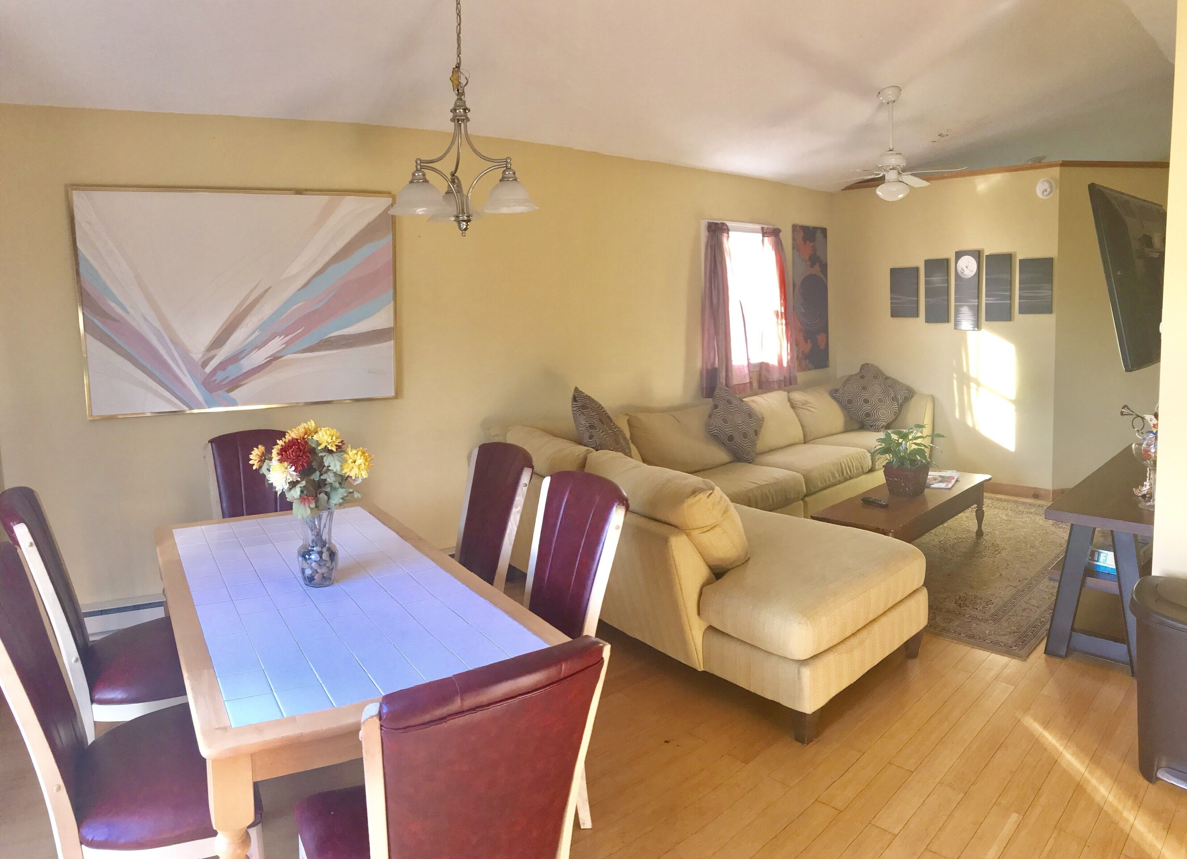 Un salón con una mesa de comedor, sofá y sillas.