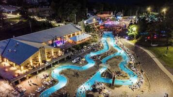 Ein Resort mit gewundenem Pool, Außenbereich zum Sitzen und einem Gebäude mit flachem Dach.