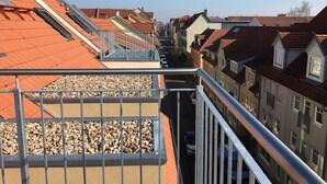 A residential area with terraced houses, a narrow street, and a metal railing. - Gästehaus Luise (Gotha)