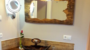 A bathroom with a wooden vanity, a round mirror, and a large mirror with a rustic frame. - Gästehaus Luise (Gotha)