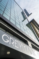 Un edificio moderno con fachada de vidrio y un letrero que dice "GREYMARK".