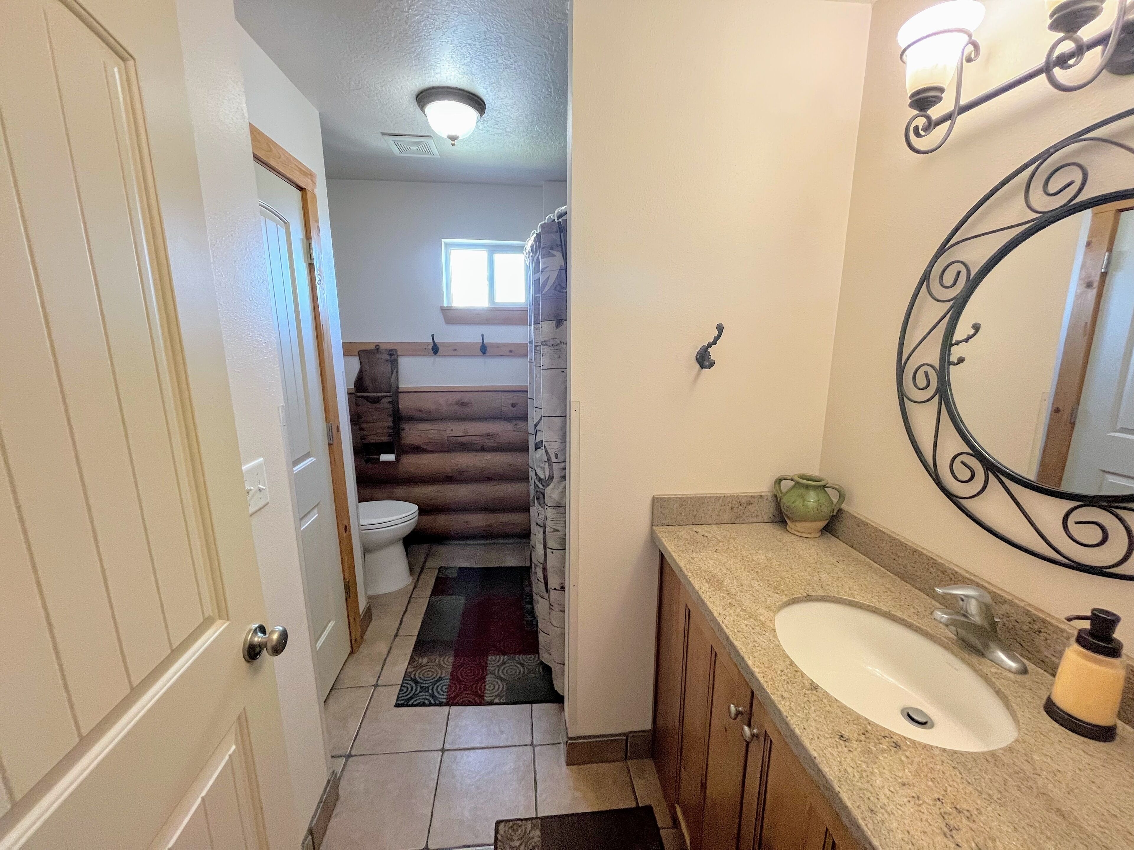 A bathroom with a white sink, a mirror, and a shower curtain.