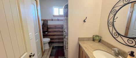 A bathroom with a white sink, a mirror, and a shower curtain.