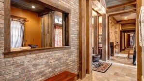 A hallway with exposed wooden beams, a brick wall, and a bench. - Large, Luxe, walk2town, 2 min DV & PC bases. Theater, game room, steam room (Park City)