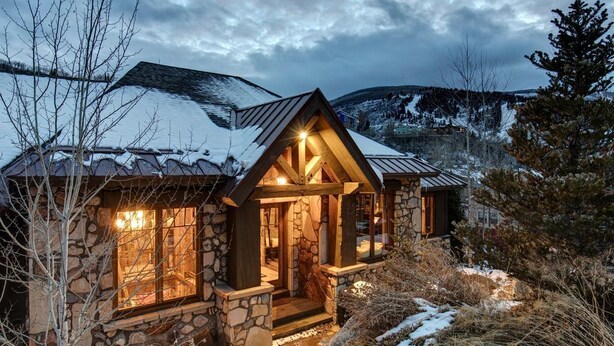 A stone cabin with a sloped roof, wooden exterior, and a lit interior. - Large, Luxe, walk2town, 2 min DV & PC bases. Theater, game room, steam room (Park City)