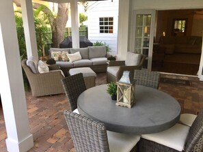 Un espace extérieur aménagé en terrasse, avec des meubles en osier, une table ronde et une lanterne.
