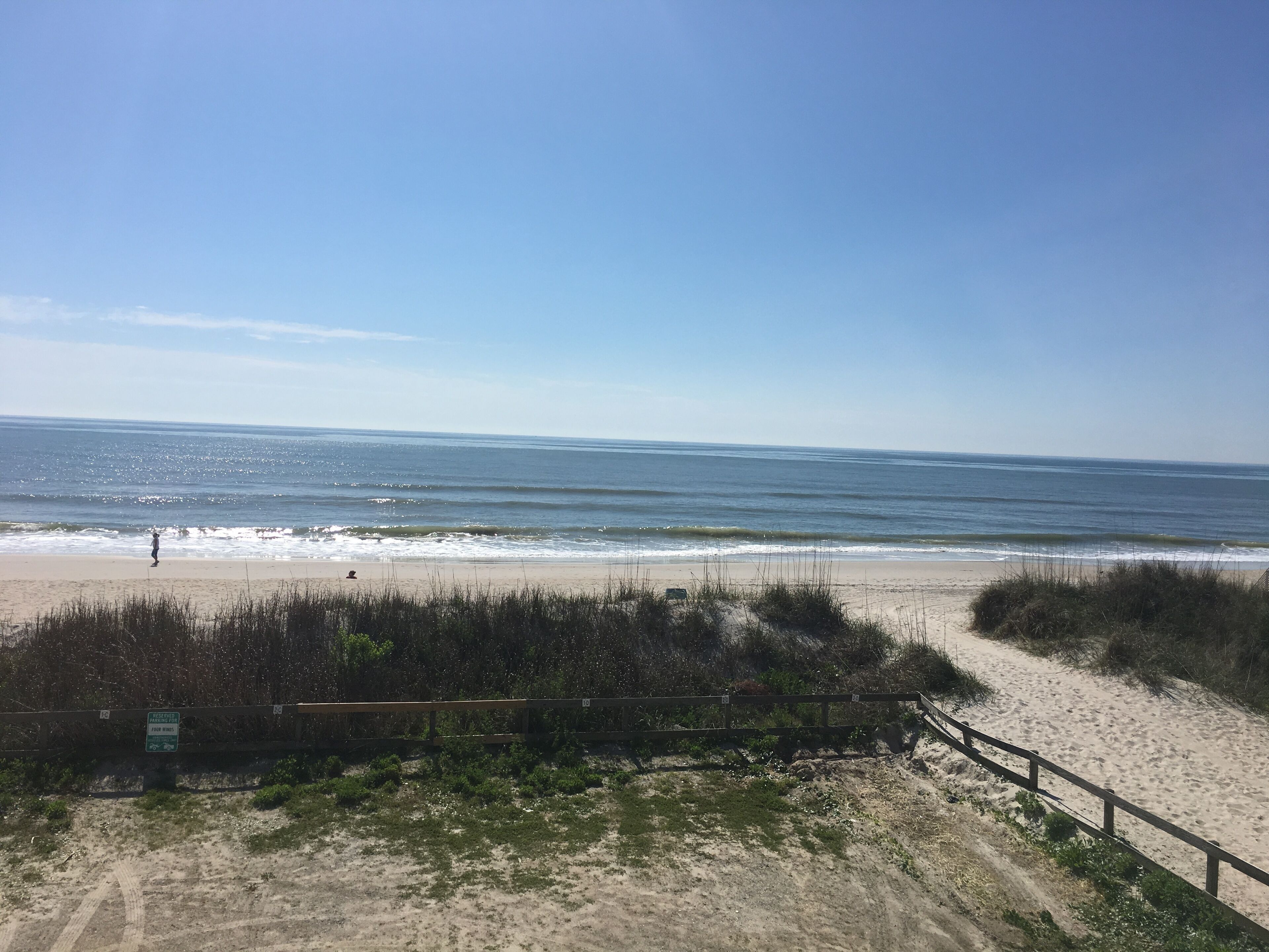 A beach with a wooden fence and a sign indicating 'Private Property No Trespassing'.