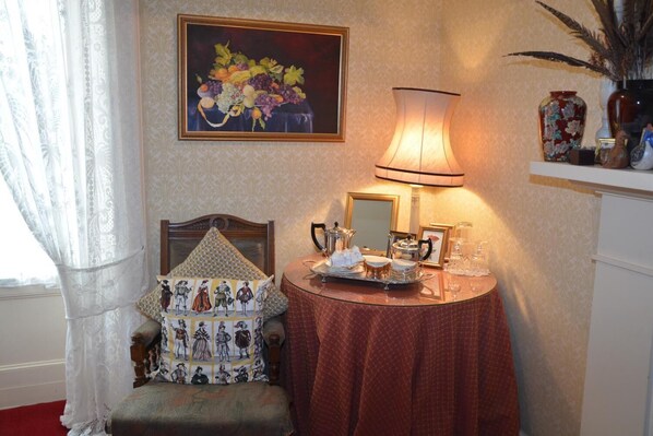 A room with a bed, a bedside table with a lamp, a painting, and a vase on a shelf. - Scaurbridge House (Thornhill)