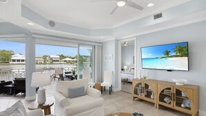 A spacious living area with a large TV, comfortable seating, and a view of the beach. - LAKEFRONT! UPDATED IN PAST 3 months ! Fish out back from porch! Minutes to beach (Miramar Beach)