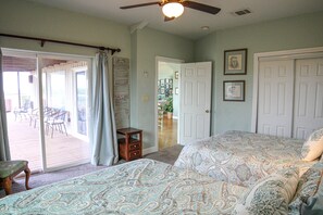A bedroom with a bed, a ceiling fan, a door, and a view of an outdoor patio. -  Secluded Lakeview, Hot Tub, 3 acres, Deer, Spacious Yard, The Preserve Venue (Canyon Lake)