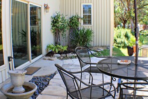 A patio with a table and chairs, a stone pathway, and potted plants. -  Secluded Lakeview, Hot Tub, 3 acres, Deer, Spacious Yard, The Preserve Venue (Canyon Lake)