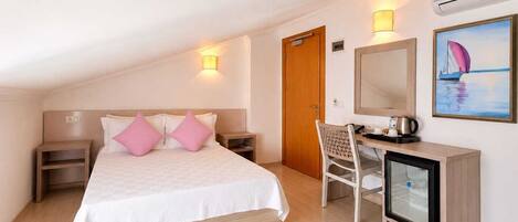 A hotel room with a bed, bedside tables, a desk with a chair, a mirror, and a painting on the wall.