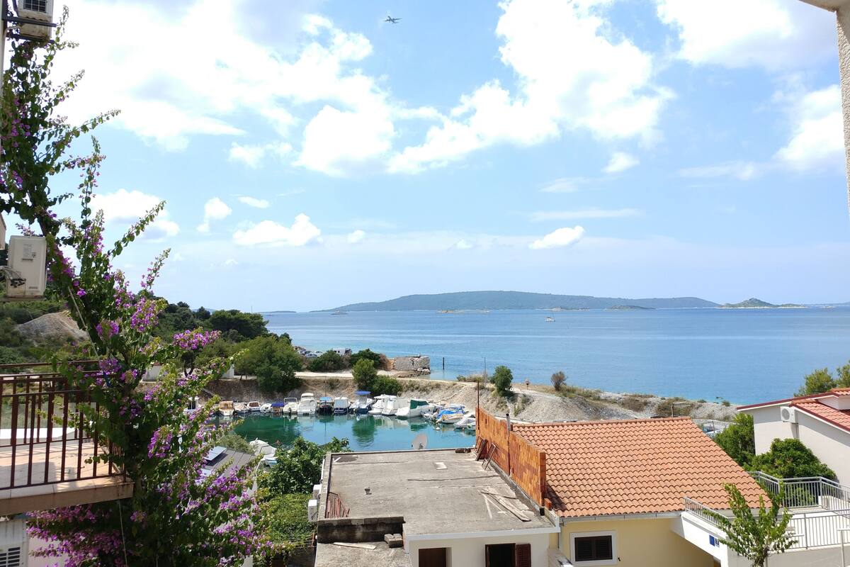 A coastal view with a marina, boats, and a clear sky.