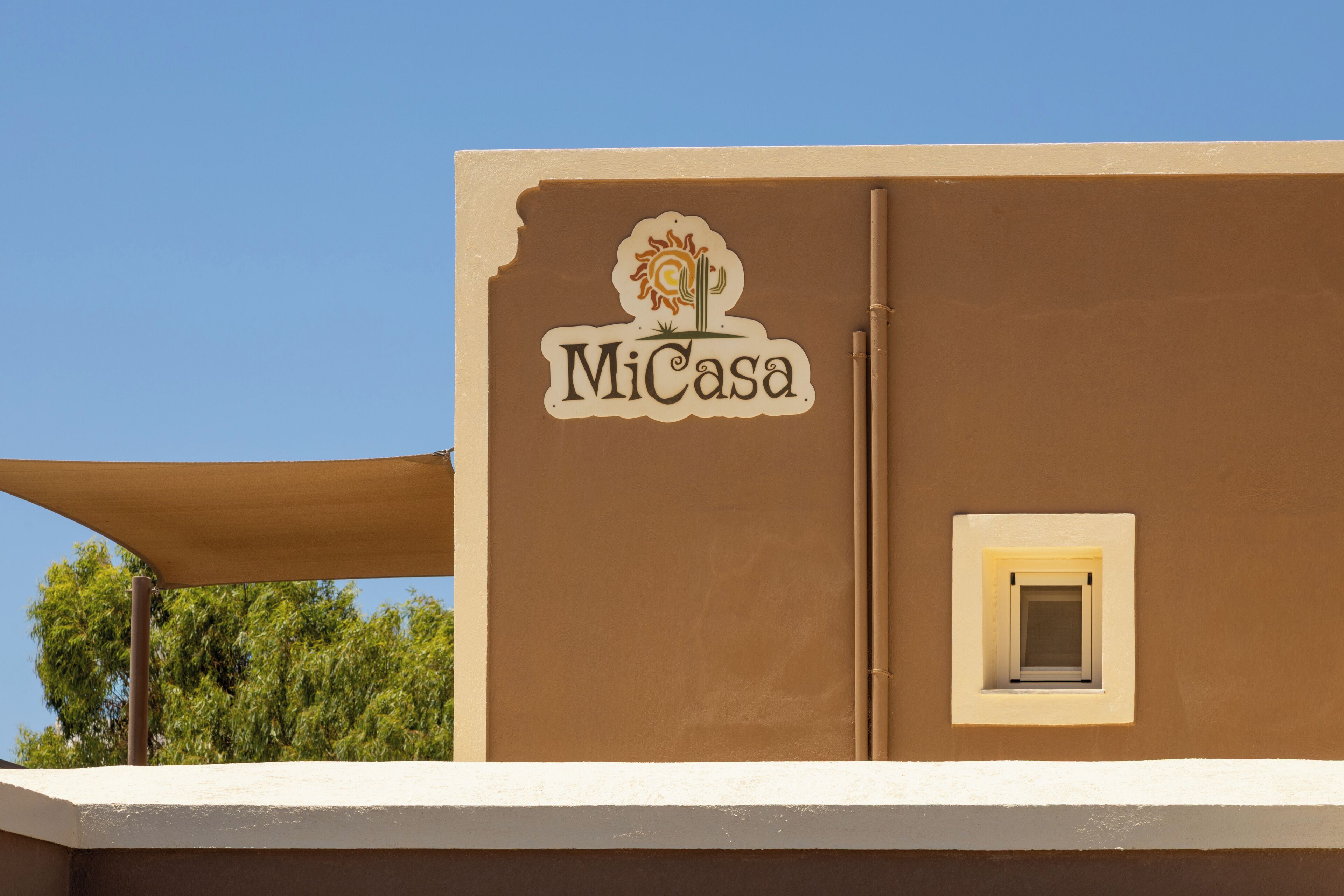 A building with a sign that reads "MiCasa" and a small window.
