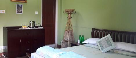 Une chambre à coucher avec un lit, une commode, un miroir et une porte.