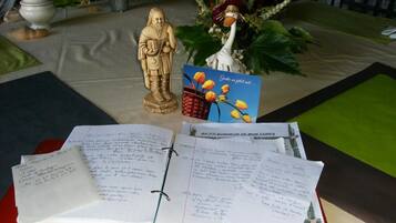 Una mesa con una estatua, una tarjeta y un cuaderno.
